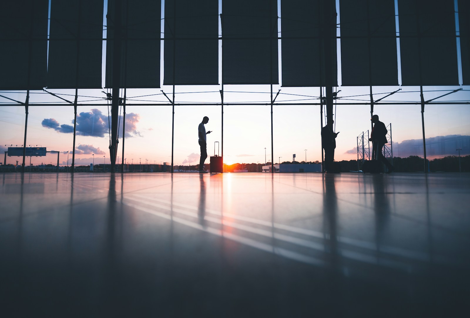 Traveller at an airport window at sunset